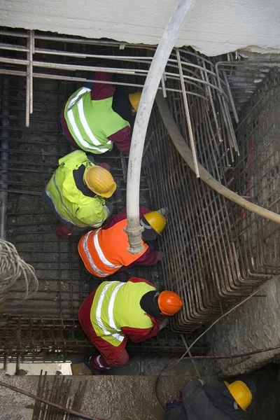 Construction workers build metal formwork for concrete tunnel