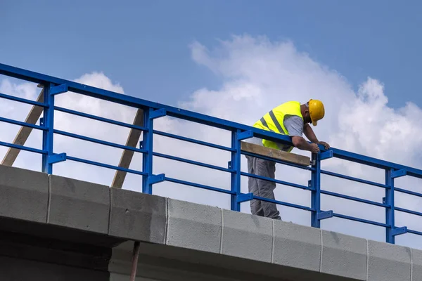 Trabalhador Montar Renovando Cerca Azul Viaduto Sobre Estrada — Fotografia de Stock