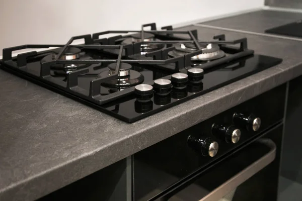 Fragment the stainless cooking plate. The steel gas hob detail on black stone surface. — Stock Photo, Image