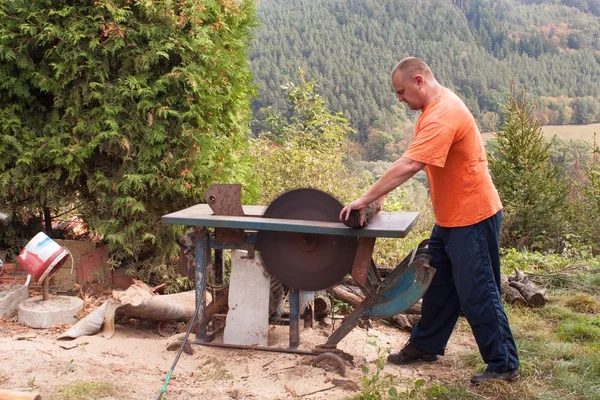 El hombre corta madera. Hombre cortando leña, preparándose para el invierno. Leña para calefacción . —  Fotos de Stock