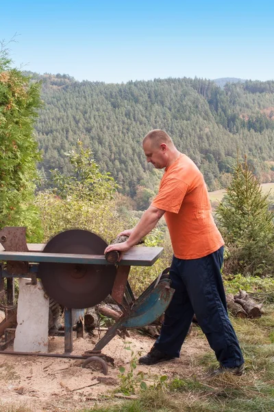 L'uomo taglia la legna. Uomo che taglia legna da ardere, si prepara per l'inverno. legna da ardere per riscaldamento . — Foto Stock