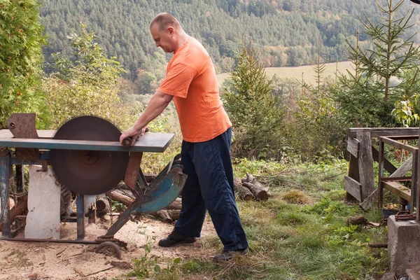 Man cuts wood. Man cutting firewood, preparing for winter. Firewood for heating. — Stock Photo, Image