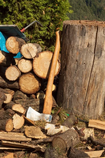 Vecchia ascia su tronco e legna da ardere. Ascia tagliata a legna dopo aver tagliato la legna da ardere . — Foto Stock