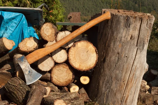 Viejo hacha en el tronco y leña. Hacha cortada en madera después de cortar leña . — Foto de Stock