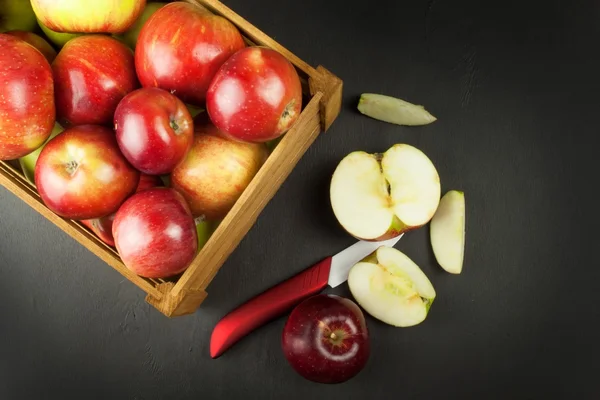 Manzanas rojas frescas de otoño en caja de madera de estilo granja. Venta de productos agrícolas. Publicidad para la venta de frutas. Cuchillo de cerámica fruta . — Foto de Stock