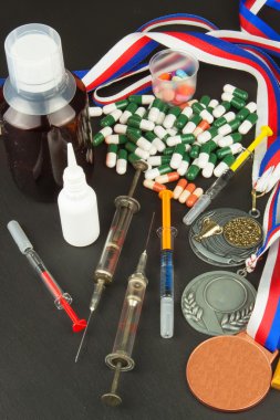 Sporda doping. Spor için anabolik steroidkötüye. Anabolik steroidler ahşap bir masaya döküldü. Sporda sahtekarlık. İlaç endüstrisi. Yanlış zafer.