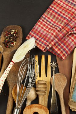 Ahşap masa üzerinde mutfak eşyaları. Araçlar pişirin. Yemek gerekiyor. Siyah ahşap zemin üzerine Ahşap mutfak eşyaları kümesi. 