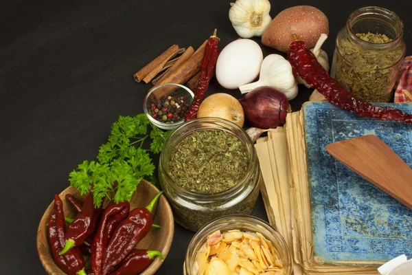 Livro de receitas e especiarias na mesa de madeira. Livro de receitas e ingredientes. Alho, pimentão e cebola. Ingredientes para cozinhar. Home Cozinha . — Fotografia de Stock