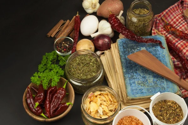 Livro de receitas e especiarias na mesa de madeira. Livro de receitas e ingredientes. Alho, pimentão e cebola. Ingredientes para cozinhar. Home Cozinha . — Fotografia de Stock