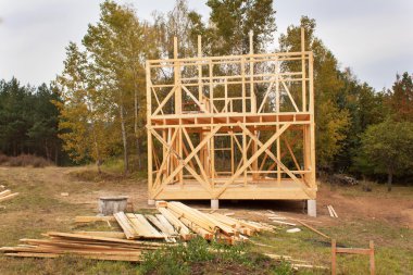 Yağmurlu sonbahar günü inşaat sahasında. Ormanın içinde ahşap bir ev inşaatı. Ev inşaatı. Ekolojik inşaat. Müstakil ev inşaatı.