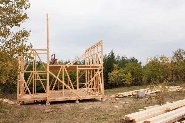 Día de otoño con llovizna en el sitio de construcción. Construcción de una casa de madera en el bosque. Construcción de la casa. Construcción ecológica. Construcción de la casa familiar . — Foto de Stock