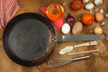 Mutfak demir tava ve yemek hazırlamak için malzemeler. Yemek pişirmek için tahta kaşıklar. Ev yemekleri, kolaylıklar. Mutfak aletleri satışı.