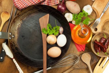 Mutfak demir tava ve yemek hazırlamak için malzemeler. Yemek pişirmek için tahta kaşıklar. Ev yemekleri, kolaylıklar. Mutfak aletleri satışı.
