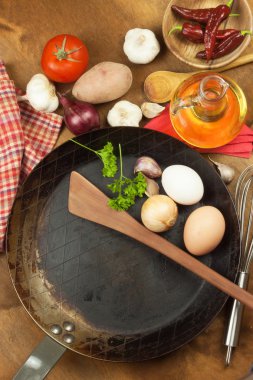 Mutfak demir tava ve yemek hazırlamak için malzemeler. Yemek pişirmek için tahta kaşıklar. Ev yemekleri, kolaylıklar. Mutfak aletleri satışı.