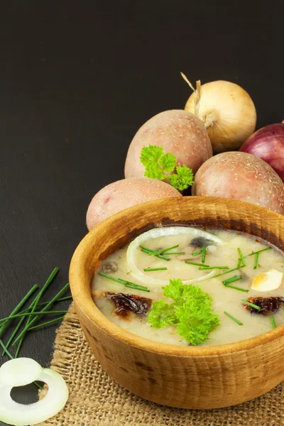 Homemade potato soup with mushrooms. Bowl with potato soup on wooden table. Food preparation.