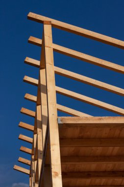 Çatı kirişleri. Güneşli sonbahar akşam bir ahşap evin inşaat sahasında. Bitmemiş ev.