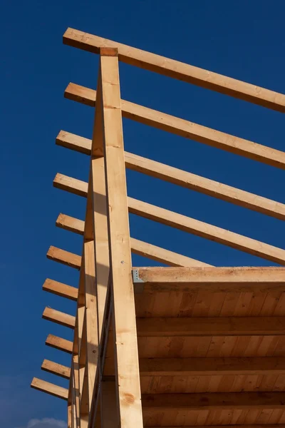 Roof beams. Sunny autumnal evening at the construction site of a wooden house. Unfinished house. — Stock Photo, Image