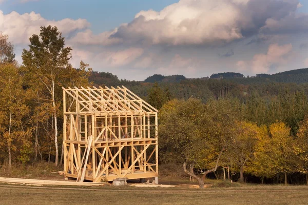 Vigas de techo. Soleado atardecer otoñal en el sitio de construcción de una casa de madera. Casa inacabada . — Foto de Stock