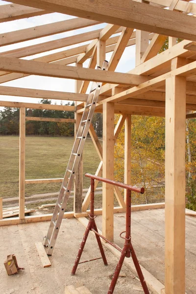 Vigas de techo. Soleado atardecer otoñal en el sitio de construcción de una casa de madera. Casa inacabada . — Foto de Stock