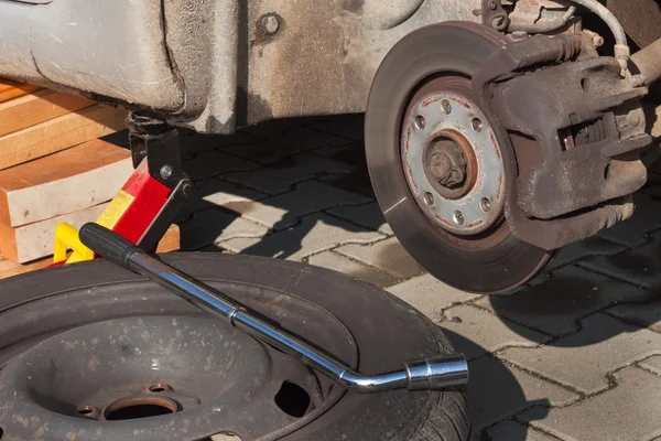Changer les pneus ou la roue avant l'hiver ou le printemps. Préparation de la voiture pour l'hiver. Réparation des pneus fissurés . — Photo