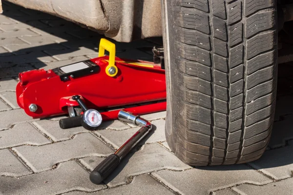 Changer les pneus ou la roue avant l'hiver ou le printemps. Préparation de la voiture pour l'hiver. Réparation des pneus fissurés . — Photo