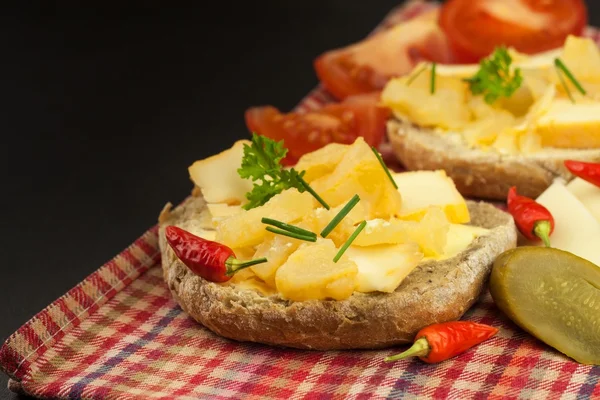 Dos tipos de queso en el pan. Desayuno saludable en la mesa de la cocina. Pan con queso tomate cherry y chile . — Foto de Stock