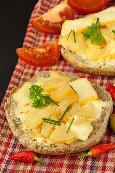 两种奶酪的面包。健康的早餐在厨房的桌子上。面包与奶酪樱桃番茄和辣椒. — 图库照片