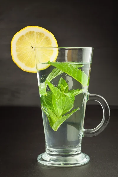 Refreshing mint and lemon. Homemade lemonade with fresh lemon and mint. Mint julep in glass on the wooden background. — ストック写真