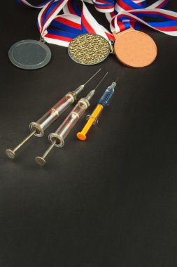 Şırınga ve madalya. Sporda doping. Spor için anabolik steroid kötüye. Anabolik steroidler ahşap bir masaya döküldü. Dolandırıcılık spor.