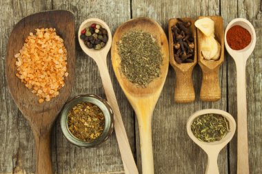 Tahta kaşık baharat. Otlar. Tarçın ve diğer ahşap rustik arka plan üzerinde. Biber. Farklı baharatlar ve otlar büyük koleksiyonu. Tuz, kırmızı biber. Baharat satışı.