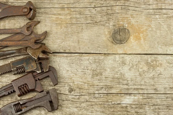 Dirty set of hand tools on a wooden background. Old rusty tools. Equipment for locksmith and metalworking shop. Sales tools for assembly workers. Old shop. — Stock Photo, Image