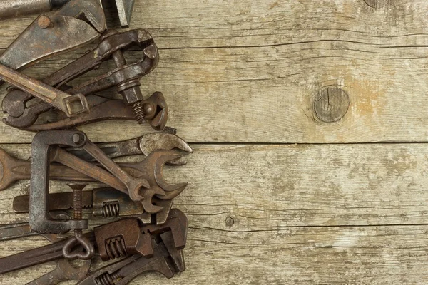 木製の背景に手用具の汚れたセット。古いさびたツールです。鍵屋と金属加工する装置です。組立作業者営業ツールです。古い店. — ストック写真