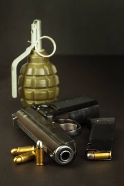 Tabanca ve bir el bombası masanın üzerinde. Savaş için onu hazırlamak. Tabanca Mühimmat üzerinde koyu ahşap bir masa ile. Silah ve mühimmat satışı. Cephane reklam. Yeni silah ve mühimmat.