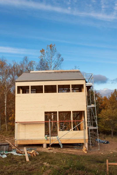 Construcción de casa ecológica. Trabajos externos en la envolvente del edificio. La estructura de madera de la casa cerca del bosque . — Foto de Stock