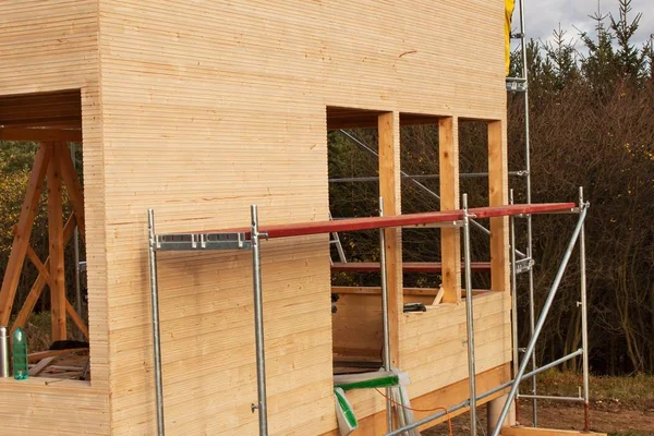 Construcción de casa ecológica. Trabajos externos en la envolvente del edificio. La estructura de madera de la casa cerca del bosque . — Foto de Stock