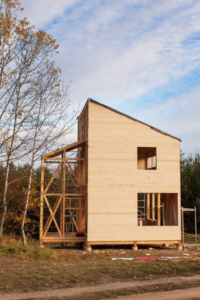 Construction of ecological house. External work on the building envelope. The wooden structure of the house near the forest.