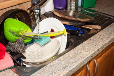 Dirty dishes in the sink after family celebrations. Home cleaning the kitchen. Cluttered dishes in the sink. Housework. clipart