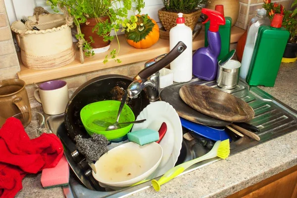 Skitne tallerkener i vasken etter familiefeiringer. Hjemme og vasker kjøkkenet. Stekte tallerkener i vasken. Husarbeid . – stockfoto