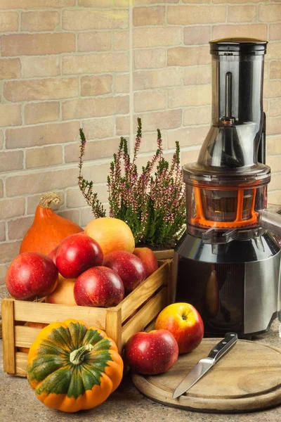 Saftpresse und Apfelsaft. Zubereitung gesunder frischer Säfte. Äpfel in der Küche entsaften. Verarbeitung herbstlicher Früchte. — Stockfoto