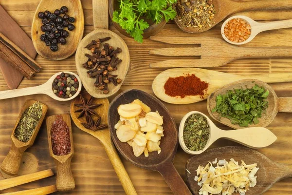 Varios tipos de especias en la mesa de la cocina. Sazonando la comida. Ventas de especias exóticas. Publicidad en especias. Especias en polvo sobre cucharas en fondo de mesa de madera . — Foto de Stock