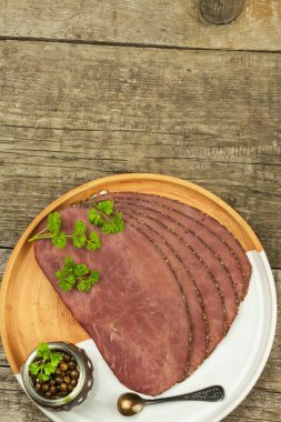 Ahşap bir masa üzerinde soğuk biftek. Sığır eti incelik. Soğuk içecekler hazırlanıyor. Geleneksel yemek. Yeşil biber ile sığır eti biftek.