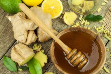 Zencefil çayı grip karşı hazırlanıyor. Soğuk algınlığı için geleneksel tedavi. Ahşap masa zencefil, limon ve bal kase. Rustik ahşap arka plan. Ev Eczanesi.