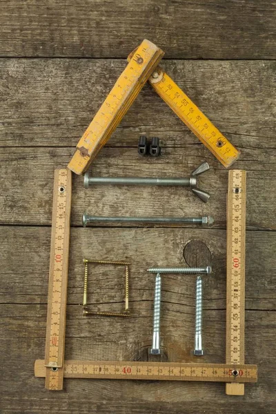 Planes para construir una casa. Fondo rústico de madera. Herramientas para constructores. Arquitecto diseñando una casa para una familia joven. Casa de clavos y tornillos. Necesario para la construcción. Ideas sobre construir una casa . —  Fotos de Stock