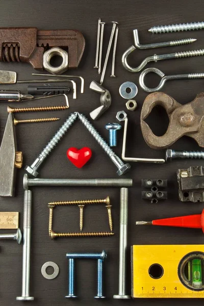 Pläne für das Familienleben. Bau eines Hauses für die Familie. zum Bauen benötigt. Bauteile. Schrauben und Werkzeuge für den Bau. Planung für den Bau des Hauses. Modellhaus der Komponenten — Stockfoto