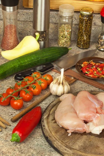 Raw chicken breast fillets on kitchen breadboard. Preparation of home diet meals with vegetables and cheese. Dietary chicken meat. — Stock Photo, Image