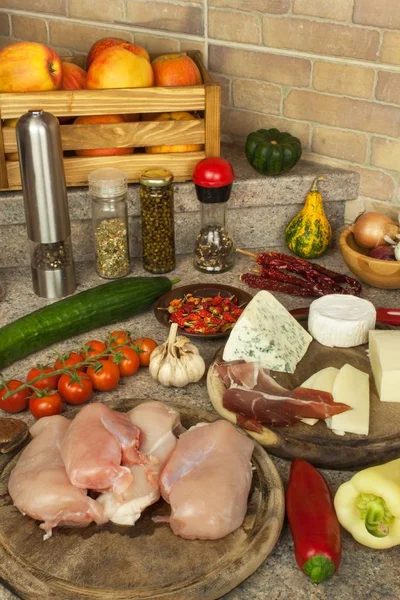 Filets de poitrine de poulet crus sur planche à pain de cuisine. Préparation de repas diététiques maison avec des légumes et du fromage. Viande de poulet diététique . — Photo