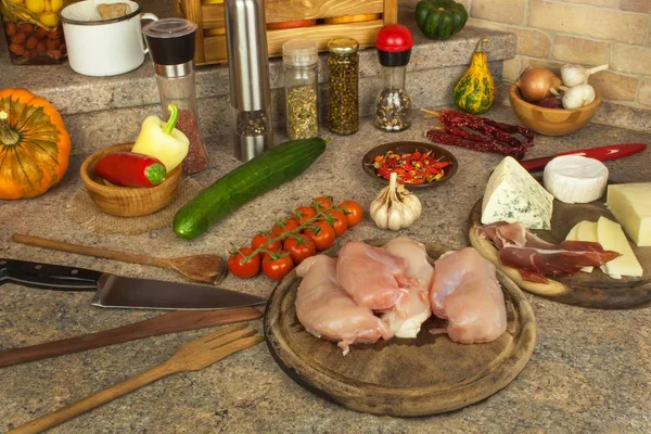 Filets de poitrine de poulet crus sur planche à pain de cuisine. Préparation de repas diététiques maison avec des légumes et du fromage. Viande de poulet diététique . — Photo