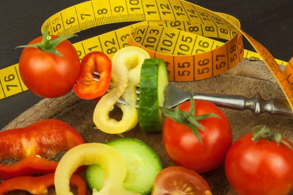 Sekalaisia vihanneksia haarukassa. Kevyt konsepti. Liikalihavuuden riski. Tuoretta ruokaa. Raaka vihannekset mustalla pöydällä . — kuvapankkivalokuva