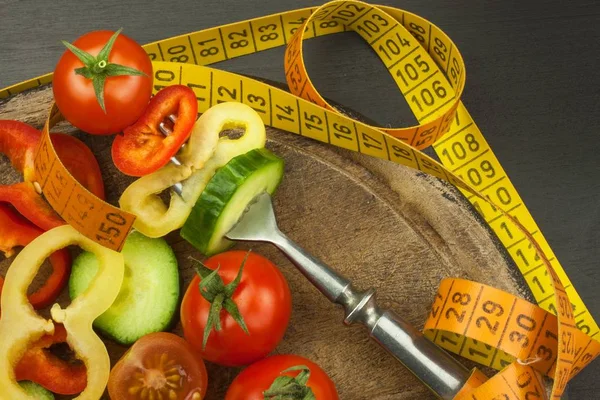 Legumes misturados em um garfo. Conceito de dieta. O risco de obesidade. Dieta de alimentos frescos. Legumes crus em uma mesa preta . — Fotografia de Stock