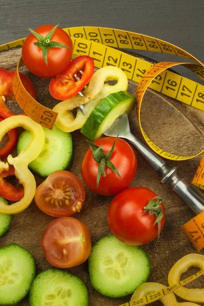 포크에 혼합된 야채입니다. 다이어트 개념입니다. 비만의 위험입니다. 신선한 음식 다이어트입니다. 블랙 테이블에 생 야채. — 스톡 사진